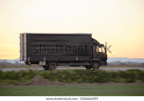Cargo truck driving\
on highway hauling goods in evening. Delivery transportation and\
logistics concept