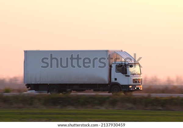 Cargo truck driving on highway hauling goods in\
evening. Delivery transportation and logistics concept. Kyiv,\
Ukraine - October 12,\
2021.