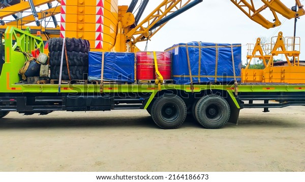 A\
cargo truck loaded with tire, drum and pallet\
boxes.