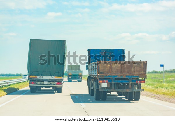 Cargo van on the road. Dangerous\
overtaking trucks on the road. Heavy vehicles with\
trailers