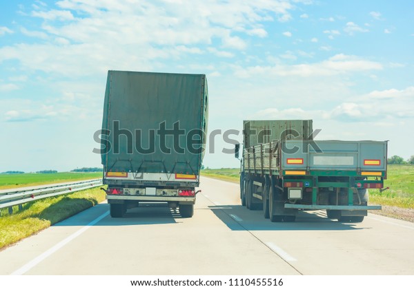 Cargo van on the road. Dangerous\
overtaking trucks on the road. Heavy vehicles with\
trailers