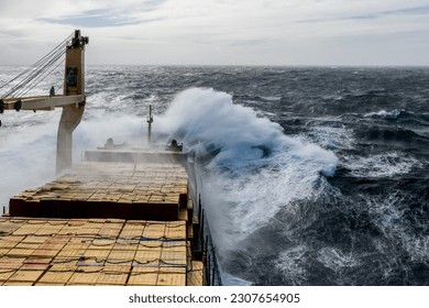 Cargo vessel with deck cargo at stormy sea. View from navigational bridge. Stormy sea, Bad weather. Gale. Rough sea.