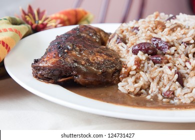 Caribbean style jerk chicken served with rice mixed with red kidney beans. Shallow Focus on the chicken.