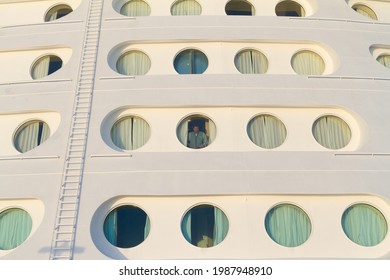 Caribbean, USA - April 29, 2015: A Stateroom Attendant Stands In Front Of The Porthole Of A Cruise Ship Stateroom