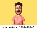 Caricature comic portrait of surprised funny young adult man looking at camera with open mouth and amazed big eyes, expressing astonishment. Indoor studio shot isolated on yellow background