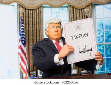 Caricature Of United States President Donald Trump Holding Up An Executive Order That States: Tax Plan, Which Was Signed As A Partisan Republican Law