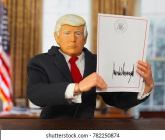 Caricature Of United States President Donald Trump Holding Up A Blank Signed Executive Order