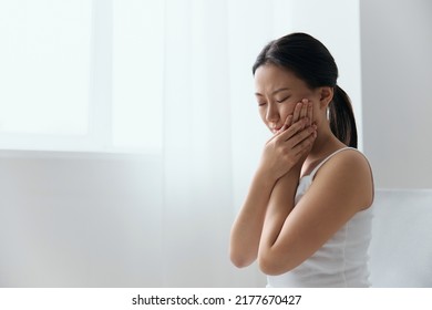 Caries Dental decay Wisdom teeth Pulpitis Periodontitis. Unhappy suffering tanned beautiful young Asian woman touch cheek at home interior living room. Injuries Poor health Illness concept. Cool offer - Shutterstock ID 2177670427