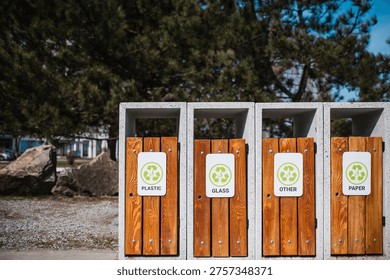 Caring about an enviroment, separating garbage into different continers. Garbage bins for separate waste sorting in park. Separate garbage collection containers on a park. Collection of plastic, paper, glass and mixed wasted for further processing