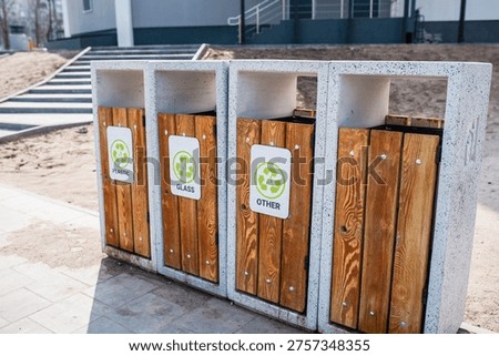 Caring about an enviroment, separating garbage into different continers. Garbage bins for separate waste sorting in park. Separate garbage collection containers on a park. Collection of plastic, paper, glass and mixed wasted for further processing
