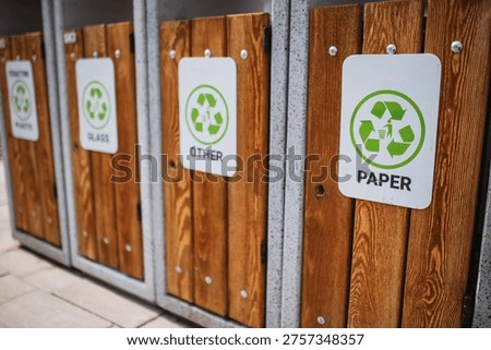 Caring about an enviroment, separating garbage into different continers. Garbage bins for separate waste sorting in park. Separate garbage collection containers on a park. Collection of plastic, paper, glass and mixed wasted for further processing