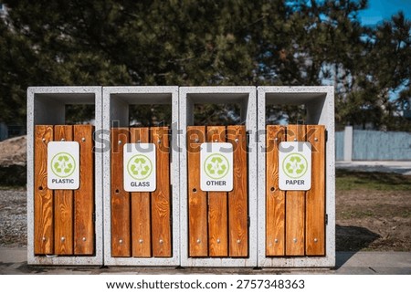 Caring about an enviroment, separating garbage into different continers. Garbage bins for separate waste sorting in park. Separate garbage collection containers on a park. Collection of plastic, paper, glass and mixed wasted for further processing
