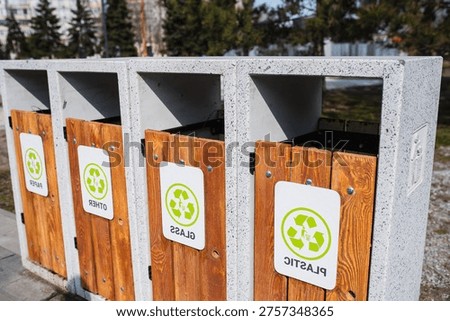 Caring about an enviroment, separating garbage into different continers. Garbage bins for separate waste sorting in park. Separate garbage collection containers on a park. Collection of plastic, paper, glass and mixed wasted for further processing