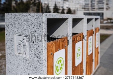 Caring about an enviroment, separating garbage into different continers. Garbage bins for separate waste sorting in park. Separate garbage collection containers on a park. Collection of plastic, paper, glass and mixed wasted for further processing