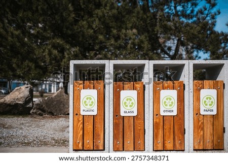 Caring about an enviroment, separating garbage into different continers. Garbage bins for separate waste sorting in park. Separate garbage collection containers on a park. Collection of plastic, paper, glass and mixed wasted for further processing