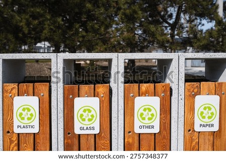 Caring about an enviroment, separating garbage into different continers. Garbage bins for separate waste sorting in park. Separate garbage collection containers on a park. Collection of plastic, paper, glass and mixed wasted for further processing