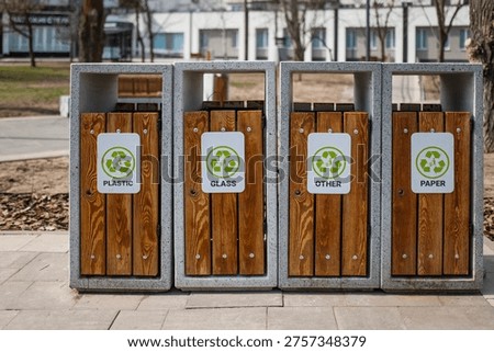 Caring about an enviroment, separating garbage into different continers. Garbage bins for separate waste sorting in park. Separate garbage collection containers on a park. Collection of plastic, paper, glass and mixed wasted for further processing