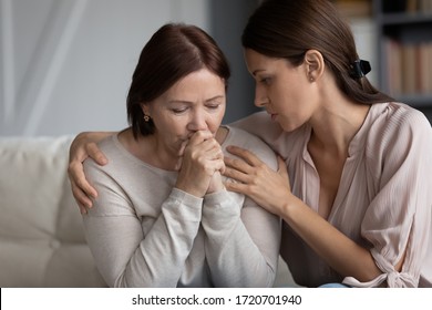Caring adult daughter comforting soothing sad middle aged mother, holding shoulders, discussing problems, young woman hugging mature mum, expressing empathy and support, helping with troubles