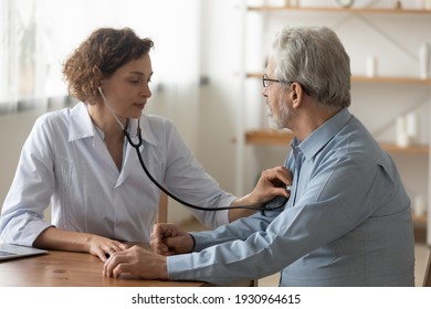 Caring Caucasian female doctor use phonendoscope examine mature male patient heart rate at consultation in hospital. Woman nurse or GP use stethoscope listen to senior man heartbeat in clinic.