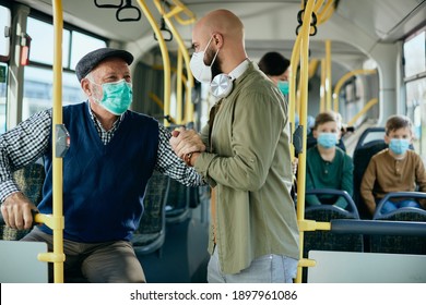 Caring commuter helping senior man to get up from the seat while traveling by public transport during coronavirus pandemic.  - Powered by Shutterstock