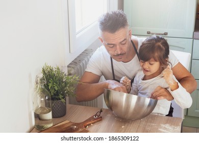 Caring Dad And Cute Little Preschooler Daughter Cooking In The Kitchen Together - Happy Father And Little Girl Child Making Pizza Or Bread Dough At Home - Cooking Together Concept - Family In Kitchen