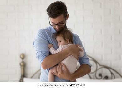 Caring dad holding rocking, calming adorable baby, holding little daughter In arms, with love, tenderness, affection, enjoying being new father. Fatherhood, family, parenting concept