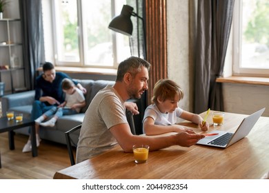 Caring Dad And Small Teen Son Study Online On Computer At Home, Write Do Homework Together. Caucasian Father Learn Help With Assignment Little Boy Child Use Laptop. Distant Education Concept.