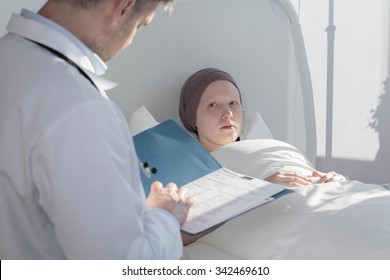 Caring Doctor Analyzing Medical Results Of Patient With Cancer