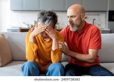 Caring elderly husband comforting his crying wife at home, senior spouses expressing emotional support and understanding in long-term relationship, loving older man soothing upset woman, closeup - Powered by Shutterstock