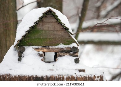 Caring for the environment. Wooden bird and small animal feeder in winter forest