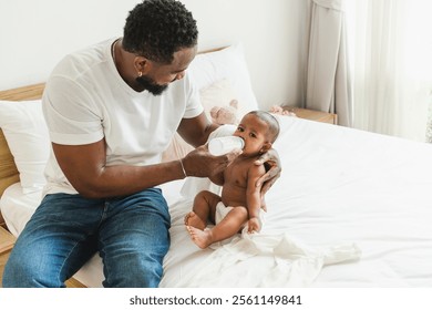 A caring father feeds his baby on a bed, showcasing a warm and nurturing moment between parent and child. Happy diversity family and newborn bathing concept. - Powered by Shutterstock