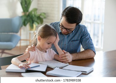 Caring Father Helping Upset Little Daughter With School Homework, Sad Pretty Girl Having Problem With Assignments, Sitting At Work Desk With Dad, Studying Together At Home, Homeschooling