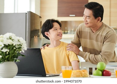 Caring Father Serving Lunch For His Teenage Son Studying At Home Due To Coronavirus Pandemic