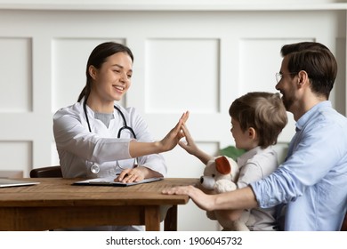 Caring female doctor give high five with small boy patient visit hospital with father. Smiling woman pediatrician greet with happy little child at consultation in clinic with dad. Healthcare concept. - Powered by Shutterstock