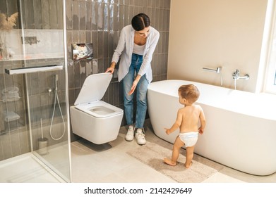 Caring female parent toilet-training her baby boy
