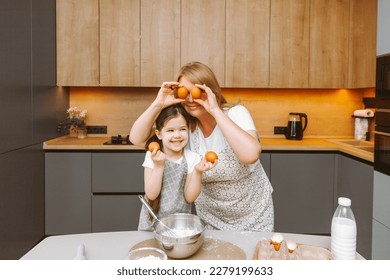 Caring grandmother and little granddaughter are having fun baking cookies together in the home kitchen. A loving elderly grandmother and granddaughter prepare a delicious sweet cake. - Shutterstock ID 2279199633