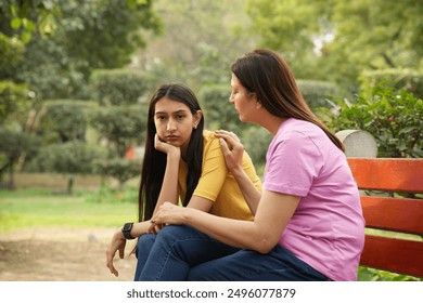 Caring Indian mother talk comfort at park. Unhappy sad young 
daughter suffering from psychological problems, loving mom support make peace with depressed introvert grown up girl - Powered by Shutterstock