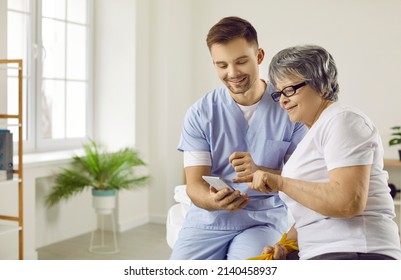 Caring Male Doctor Showing His Female Senior Patient How To Download A Useful Health Tracker App On Her Smartphone. Happy Older Lady Learning To Use A Modern Medical Application On Her Mobile Phone