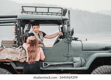 Caring man assists a woman as she climbs into a sturdy off-road car for an adventure by a misty lake at dawn. - Powered by Shutterstock