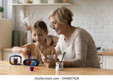 Caring mature Caucasian grandmother engaged in interesting chemistry laboratory game with cute smart little granddaughter. Senior granny and small girl child have fun do experiments in toy lab. - Powered by Shutterstock