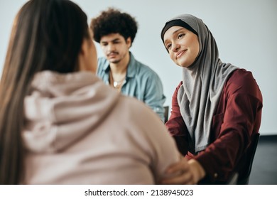 Caring Middle Eastern woman supporting new attender of group therapy to talk about herself during the meeting at mental health center.  - Powered by Shutterstock