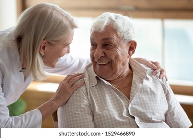 Caring Middle-aged Female Licensed Practical Nurse In White Coat Talk To Elderly Patient 80s Man, Worker Care About Old Healthcare Consumer Listens Complaints Give Support, Caregiving Service Concept