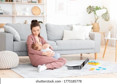 Caring Mom Nursing Baby While Working With Laptop And Papers At Home, Copy Space