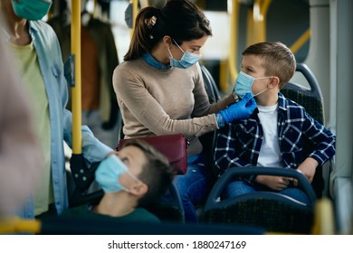 Caring mother adjusting son's protective face mask while commuting by public transportation.  - Powered by Shutterstock