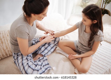 Caring Mother Applying Ointment On The Daughters Hand At Home