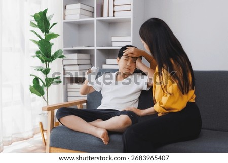 Caring mother checking the temperature of her sick son, providing comfort and support during illness