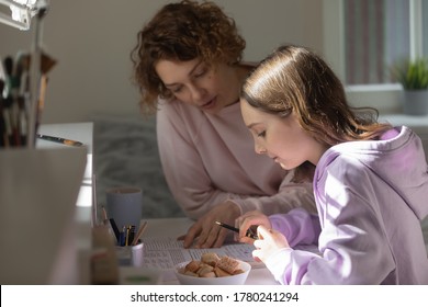 Caring mother helping to teenage daughter with school homework, sitting at desk, mum and teen girl studying together, reading textbook, teacher tutor explaining task, teaching pupil at home - Powered by Shutterstock