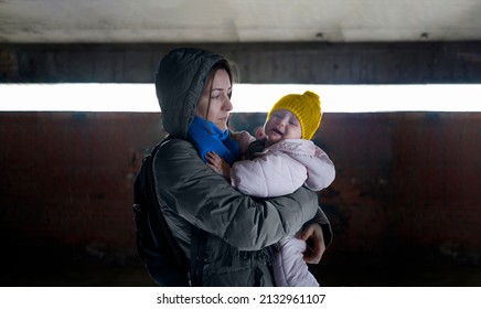 Caring mother holding her crying baby in the air raid shelter