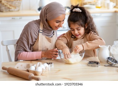 Caring Muslim Mom Teaching Her Little Daughter How To Make Dough While Baking Together In Kitchen, Happy Islamic Family Making Cookies, Enjoying Cooking Homemade Pastry, Closeup Shot