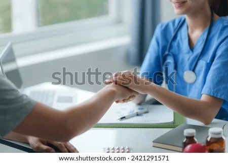 Caring nurse holding a patient's hand, providing comfort and support during a medical consultation.
